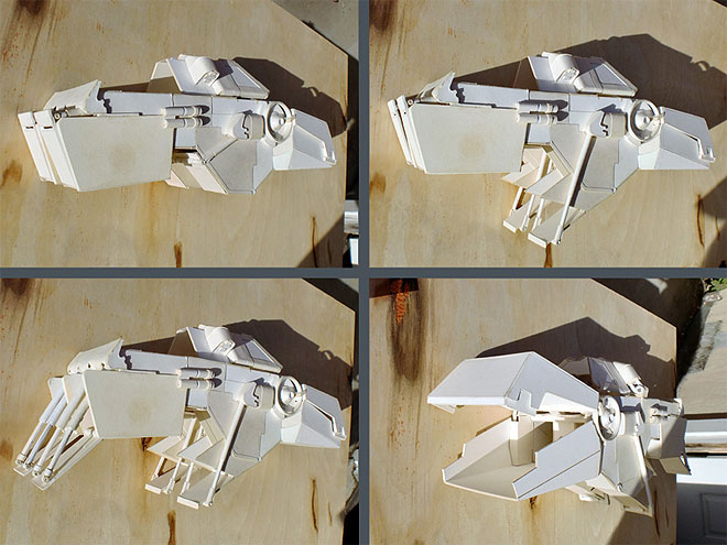 Four views of various moving parts of the paper model, with disembarkation ramps extending in stages.